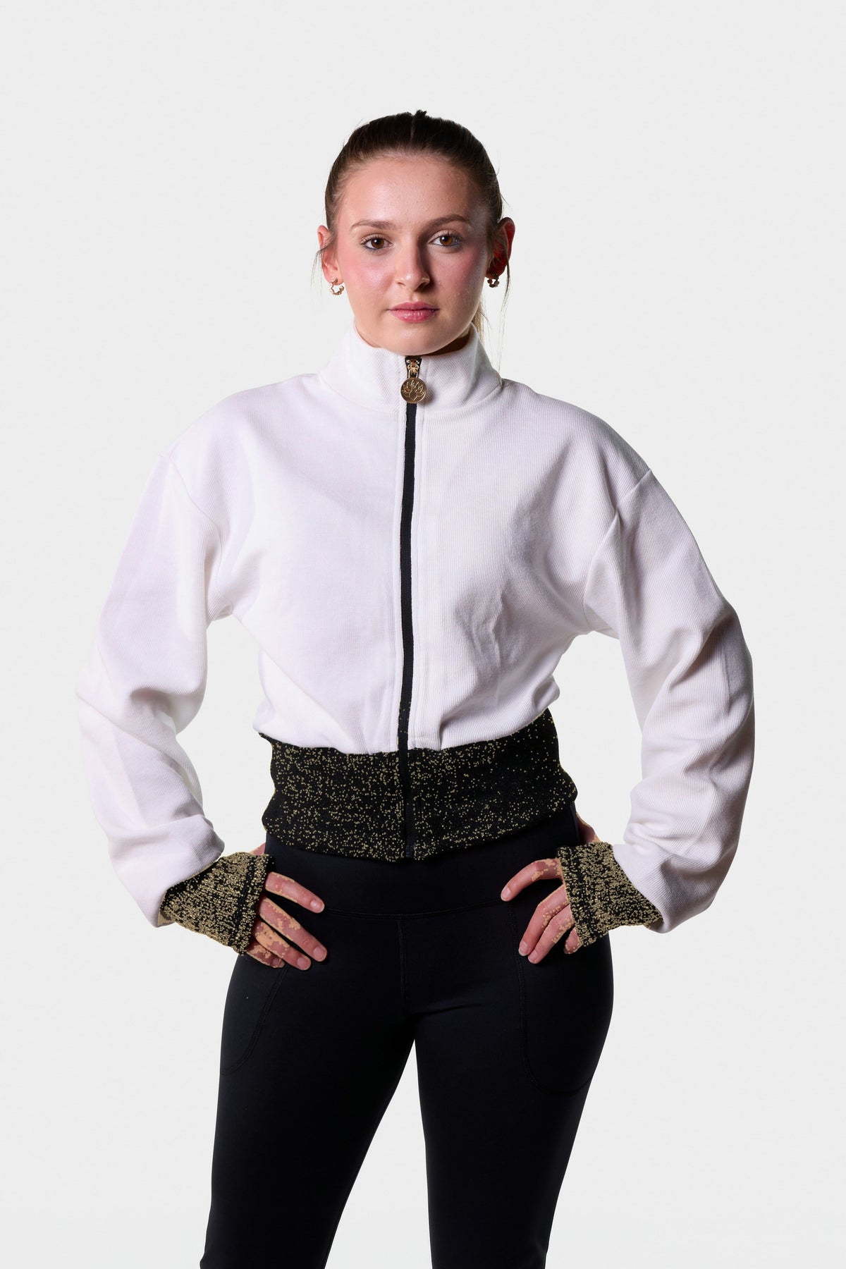 Front view of the white Paggo Artemis zip-up with Lurex waistband and cuffs, worn with the Christina Pants